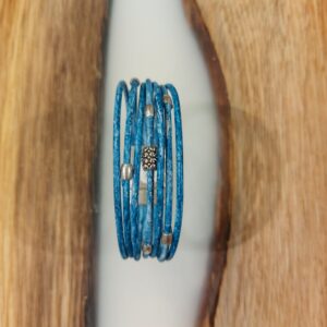Bracelet en cuir bleu lagon, composé de 7 cordons de cuir de 2 mm et orné de perles en acier inoxydable. Son fermoir magnétique assure confort et sécurité. Un accessoire élégant et moderne, parfait pour ajouter une touche colorée et sophistiquée à votre look.