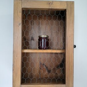 Meuble mural au charme campagnard, artisanal avec finition vieillie. Porte grillagée style "cage à poule", élégant et pratique pour votre intérieur.